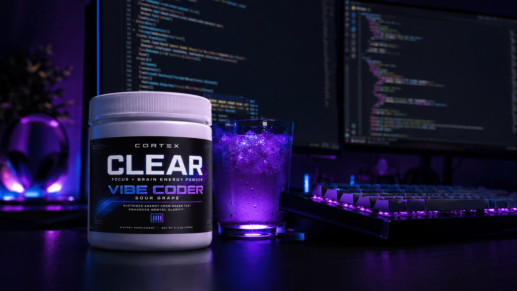 CORTEX CLEAR Vibe Coder tub and a glowing purple drink on a desk with code on the monitors